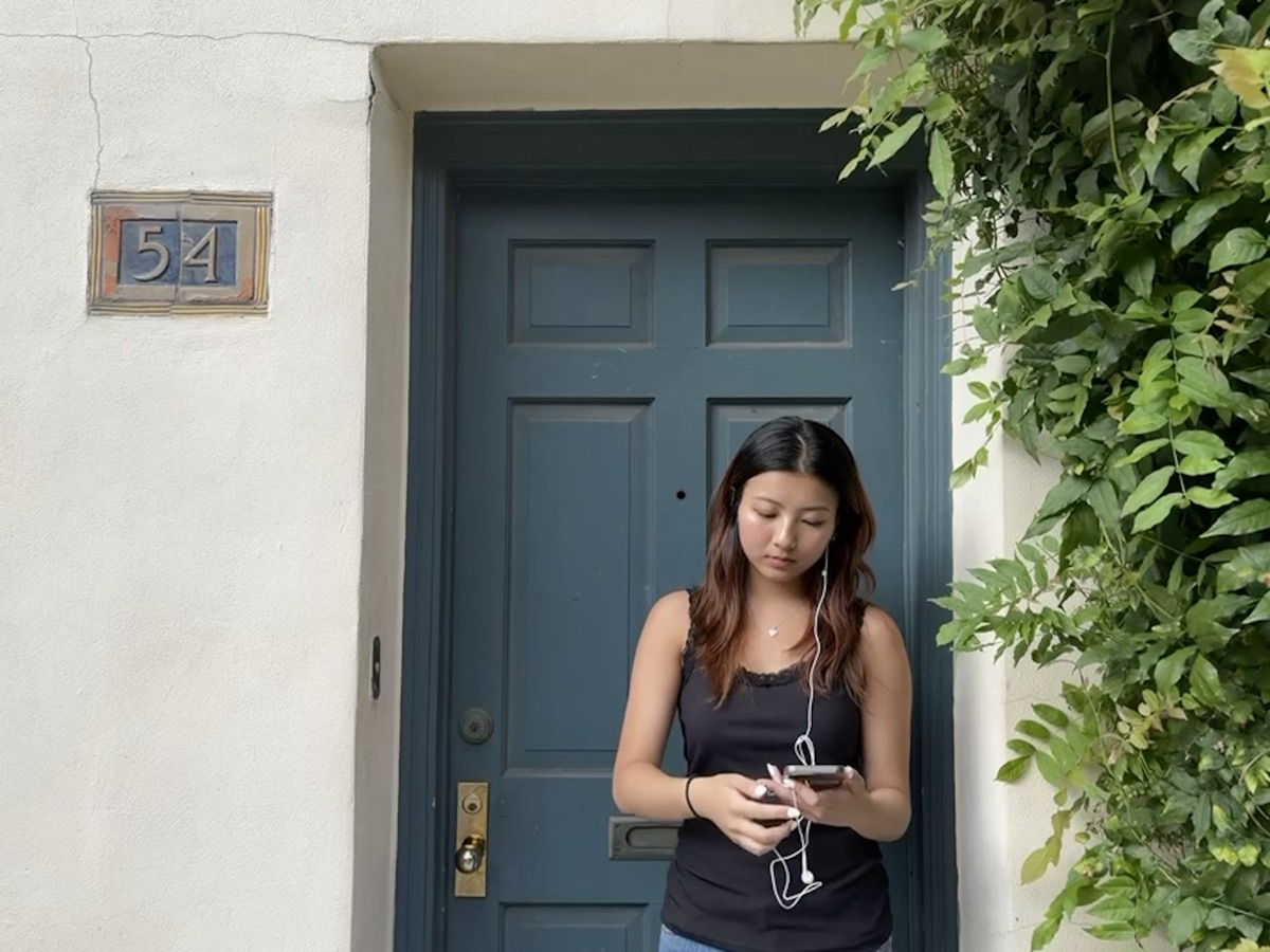 Stephanie standing in a teal doorway framed by greenery